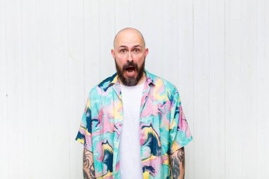 Kel adam korkmuş ve şok olmuş hissediyor, ağzı açık şaşkınlık içinde.