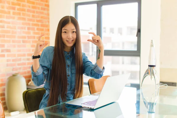 young asian woman framing or outlining own smile with both hands, looking positive and happy, wellness concept