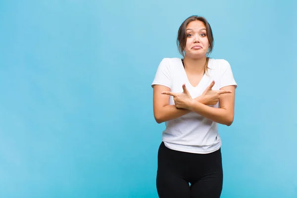 年轻的惊慌失措的女人看上去困惑而困惑 没有安全感 带着疑虑指向相反的方向 — 图库照片