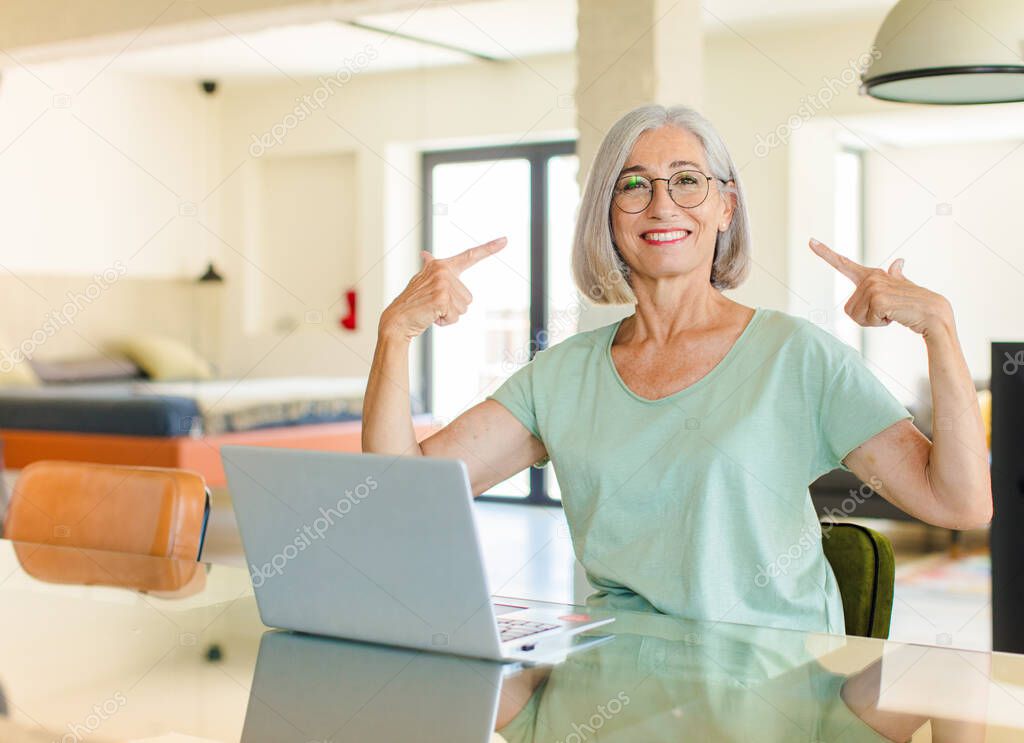 middle age woman looking proud, arrogant, happy, surprised and satisfied, pointing to self, feeling like a winner