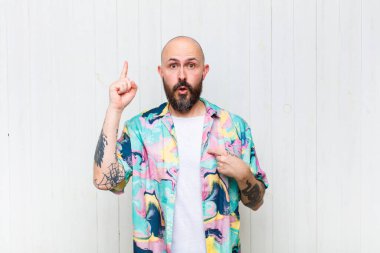 Kel adam kendini gururlu ve şaşırmış hissediyor. Kendine güvenerek kendini bir numara gibi hissediyor.