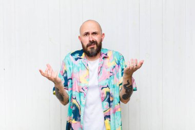 Kel bir adam bilgisiz ve kafası karışık, hangi seçeneği seçeceğinden emin değil, merak ediyor.