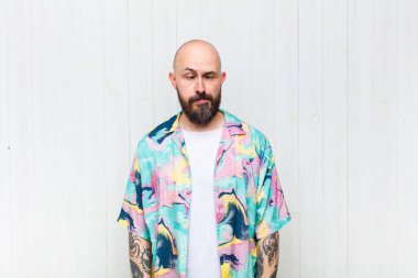 Kel adam şapşal ve komik görünüyor. Şaşı bakışlı, şakacı ve şakacı.