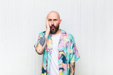 Kel adam şaşkın ve şaşkın hissediyor. Ağzı sonuna kadar açıkken yüz yüze inanmamak için tutuyor.