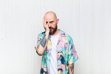 Kel bir adam yorgun, sıkıcı ve can sıkıcı bir işten sonra sıkılmış, hayal kırıklığına uğramış ve uykulu hisseder.