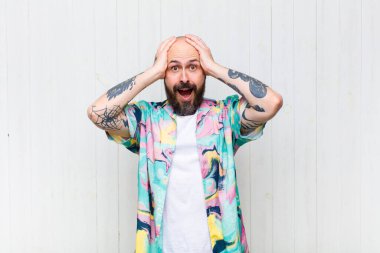 Keltoş adam ellerini kaldırıyor, ağzı açık, son derece şanslı, şaşırmış, heyecanlı ve mutlu hissediyor.