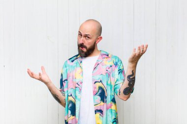 bald man shrugging with a dumb, crazy, confused, puzzled expression, feeling annoyed and clueless