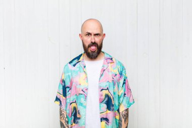 Kel adam tiksinti ve tedirginlik duyuyor, dilini dışarı çıkarıyor, iğrenç ve iğrenç bir şeyden hoşlanmıyor.