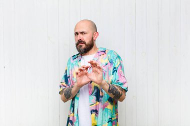 Kel adam tiksinti ve mide bulantısı hissediyor. Pis, kokan ya da kokan bir şeyden kaçıyor. İğrenç diyor.