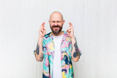 Kel adam gergin ve umutlu, şans diliyor ve dua ediyor.