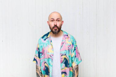 Kel adam dudaklarını birbirine bastırıyor, tatlı, eğlenceli, mutlu, sevimli bir yüz ifadesiyle, öpücük gönderiyor.