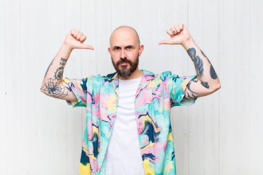 Kel adam gururlu, kibirli ve kendinden emin, tatmin olmuş ve başarılı görünüyor, kendini işaret ediyor.