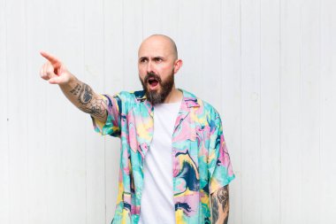 Kel adam şaşkın ve şaşırmış hissediyor, hayranlıkla yukarı bakıyor, şaşırmış, ağzı açık bakıyor.