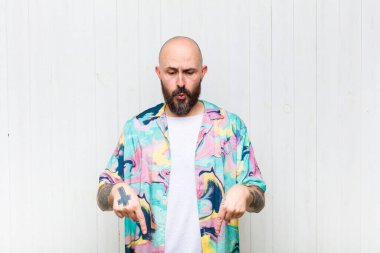 Kel adam şok olmuş, ağzı açık ve şaşkın, inançsızlık ve şaşkınlık içinde bakıyor ve onu işaret ediyor.