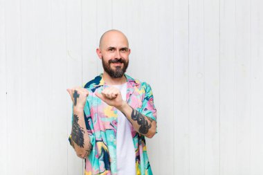 Kel adam neşeyle gülümsüyor ve yan taraftaki fotokopi alanını işaret ediyor, mutlu ve tatmin olmuş hissediyor.