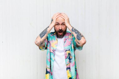 Kel adam dehşete kapılmış ve şok olmuş hissediyor. Elleri havada ve bir hata yüzünden panikliyor.