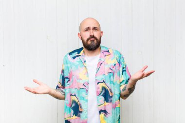 Kel adam şaşkın ve şaşkın hissediyor, doğru cevap ya da karardan emin değil, bir seçim yapmaya çalışıyor.