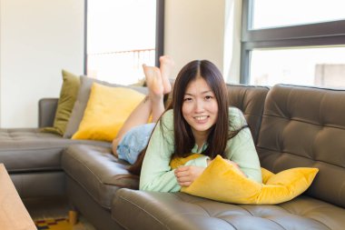 Genç Asyalı kadın endişeli, hasta, hasta ve mutsuz hissediyor. Ağrılı bir mide ağrısı ya da grip geçiriyor.