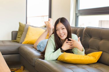 Genç Asyalı kadın romantik, mutlu ve aşık, neşeyle gülümseyen ve kalbe yakın el ele tutuşan