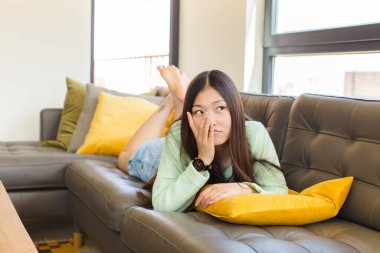 Genç Asyalı kadın yorgun, sıkıcı ve can sıkıcı bir görevden sonra sıkılmış, hayal kırıklığına uğramış ve uykulu hissediyor.