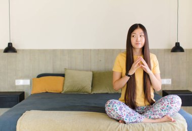 Genç Asyalı kadın entrikalar ve komplolar kuruyor, sinsi hileler ve hileler düşünüyor, kurnazlık ve ihanet