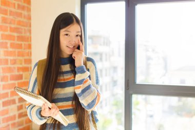 Genç Asyalı kadın sana göz kulak oluyor, güvenmiyor, izliyor, tetikte ve tetikte.