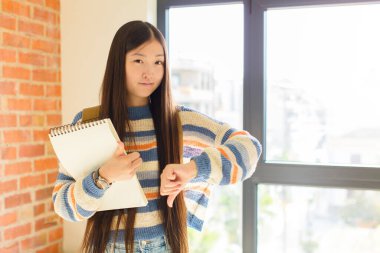 Genç Asyalı kadın kafası karışık, bilgisiz ve kararsız hissediyor, iyi ve kötü seçenekleri farklı seçeneklerde tartıyor.