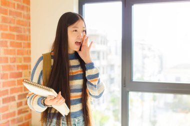 Genç Asyalı kadın profil görüşü, mutlu ve heyecanlı görünüyor, bağırıyor ve kenardaki boşluğu kopyalamak için arıyor