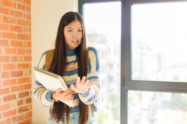 Genç Asyalı kadın tiksinti ve mide bulantısı hissediyor. Pis kokan ya da kokan bir şeyden kaçıyor. İğrenç diyor.