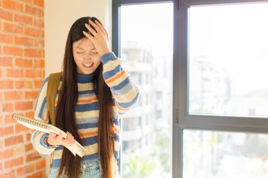 Asyalı genç bir kadın stresli ve hayal kırıklığına uğramış hissediyor. Eli kolu bağlı, yorgun, mutsuz ve migren ağrısı çekiyor.