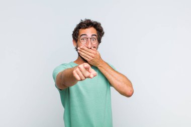 Genç sakallı adam sana gülüyor, kamerayı gösteriyor ve seninle dalga geçiyor ya da alay ediyor.