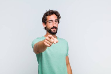 Genç sakallı adam kameraya bakıyor. Tatmin olmuş, kendine güvenen, dost canlısı bir gülümsemeyle seni seçiyor.