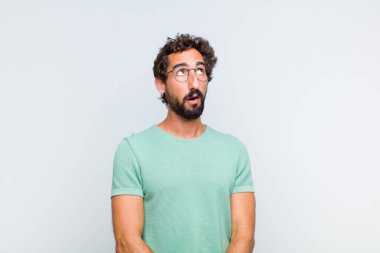 Endişeli, kafası karışık, cahil bir ifadeyle genç sakallı adam kopyalama alanına bakıyor, şüphe ediyor.