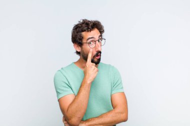 Genç sakallı adam sana göz kulak oluyor, güvenmiyor, izliyor, tetikte ve tetikte.