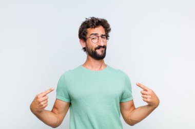 Genç sakallı adam gururlu, kibirli, mutlu, şaşırmış ve tatmin olmuş görünüyor.