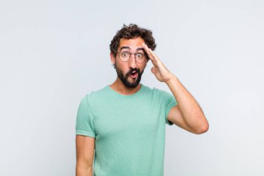 Genç sakallı adam mutlu, şaşkın ve şaşırmış görünüyor, gülümsüyor ve inanılmaz ve inanılmaz iyi haberleri fark ediyor.