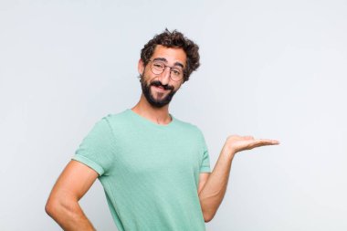 Genç sakallı adam gülümsüyor, kendinden emin, başarılı ve mutlu hissediyor, fotokopi odasında konsept veya fikir gösteriyor.