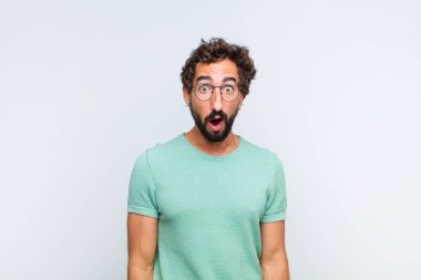 Genç sakallı adam şok olmuş ya da şaşırmış görünüyor, ağzı açık bir şekilde 
