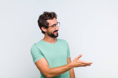 Genç sakallı adam gülümsüyor, seni selamlıyor ve başarılı bir anlaşma için el sıkışmayı teklif ediyor, işbirliği konsepti.