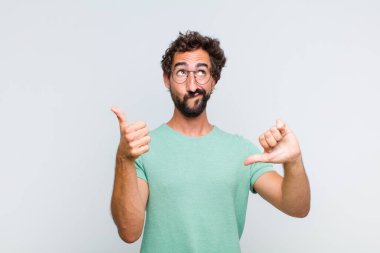 Genç sakallı adam kafası karışmış, bilgisiz ve kararsız hissediyor, iyiyi ve kötüyü farklı seçeneklerle tartıyor.