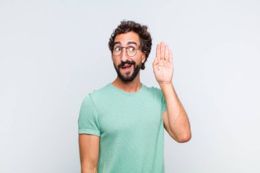 Genç sakallı adam gülümsüyor, tuhaf bir şekilde yan tarafa bakıyor, dedikoduları dinlemeye ya da bir sırrı duymaya çalışıyor.