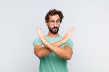 Genç sakallı adam senin bu tavırlarından rahatsız ve bıkkın görünüyor. Yeter artık! Eller önde çapraz, durmanı söylüyor.