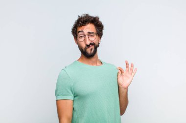 Genç sakallı adam kibirli, başarılı, pozitif ve gururlu görünüyor.