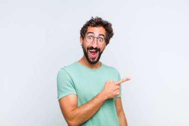 Genç sakallı adam heyecanlı ve şaşırmış görünüyor.