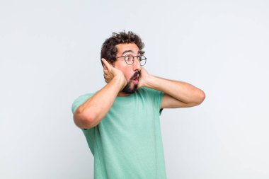 Ağzı açık sakallı genç bir adam korkunç bir hata yüzünden dehşete düşmüş ve şok olmuş görünüyor.