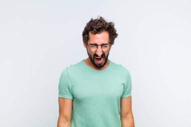 Genç sakallı adam agresif bir şekilde bağırıyor, sinirli, sinirli, öfkeli ya da sinirli görünüyor, hayır diyor.