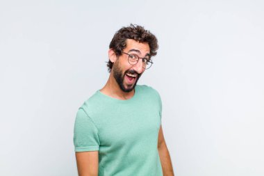 Genç sakallı bir adam, büyük, dost canlısı, kaygısız bir gülümseme, pozitif, rahat ve mutlu görünüyor, ürpertici.