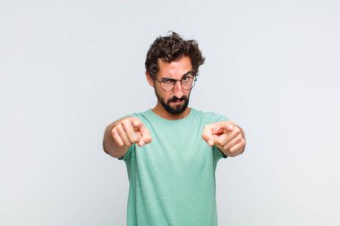 Genç sakallı bir adam kameraya hem parmaklarıyla hem de kızgın bir ifadeyle sana görevini yapmanı söylüyor.