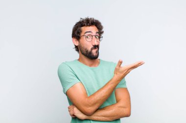 Genç sakallı adam, kafası karışık ve bilgisiz, şüpheli bir açıklama ya da düşünceyi merak ediyor.