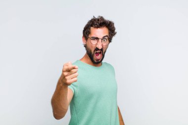 Genç sakallı adam kızgın agresif bir ifadeyle kameraya bakıyor. Öfkeli, çılgın bir patron gibi görünüyor.